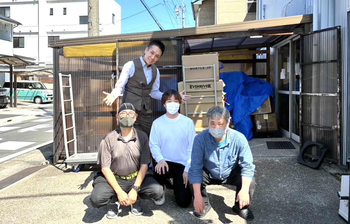 倉庫前で株式会社More Thanxの代表と協力スタッフが物流体制を確認する様子